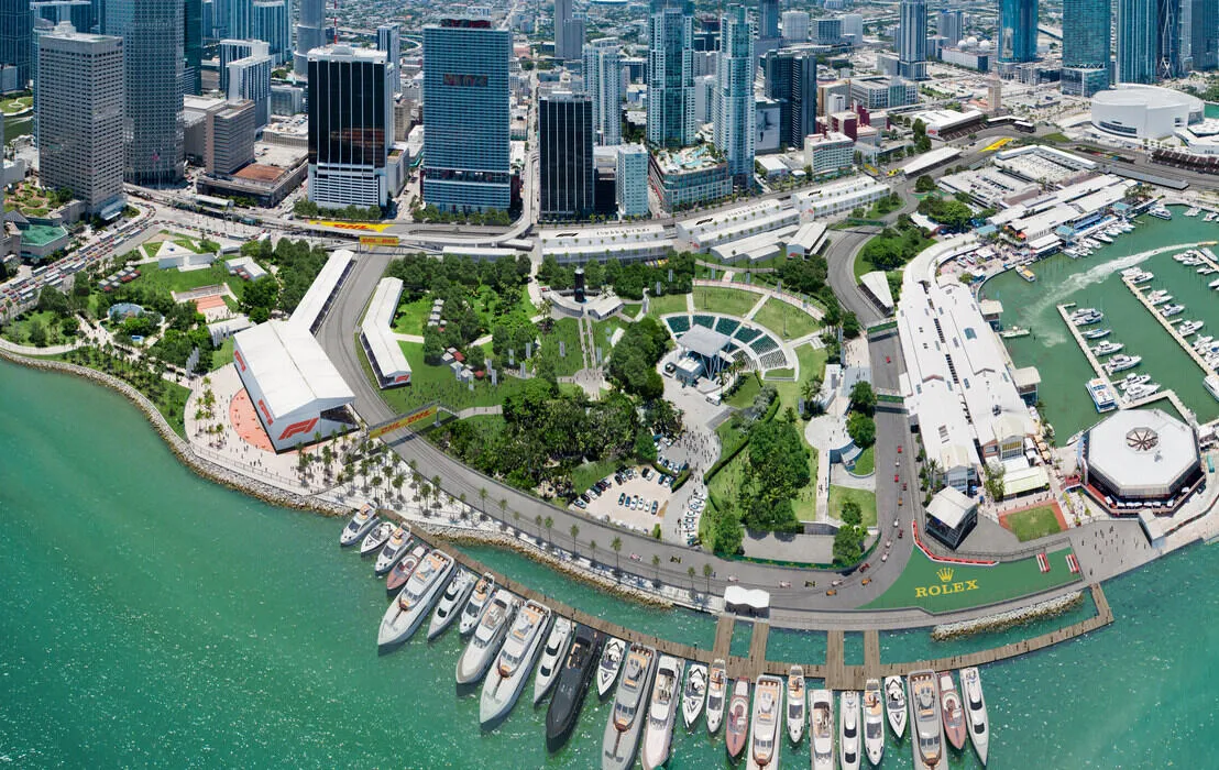 Waterfront rendering of a Formula 1 street circuit through an urban landscape with marinas, yachts, and skyscrapers — a photoreal 3D render by omegarender for Apex Circuit Design.